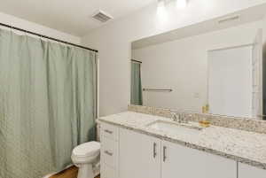 Bathroom with a shower with shower curtain and vanity
