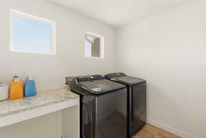 Laundry area with light wood-type flooring and washer and dryer