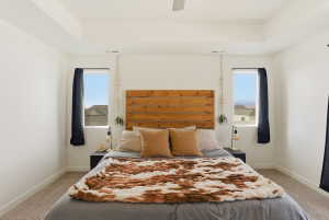 Bedroom with light colored carpet and a ceiling fan