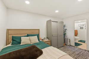 Bedroom with recessed lighting, radiator heating unit, and carpet flooring