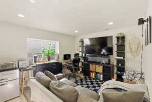 Living area with an office area, light wood-style floors, a textured ceiling, and recessed lighting