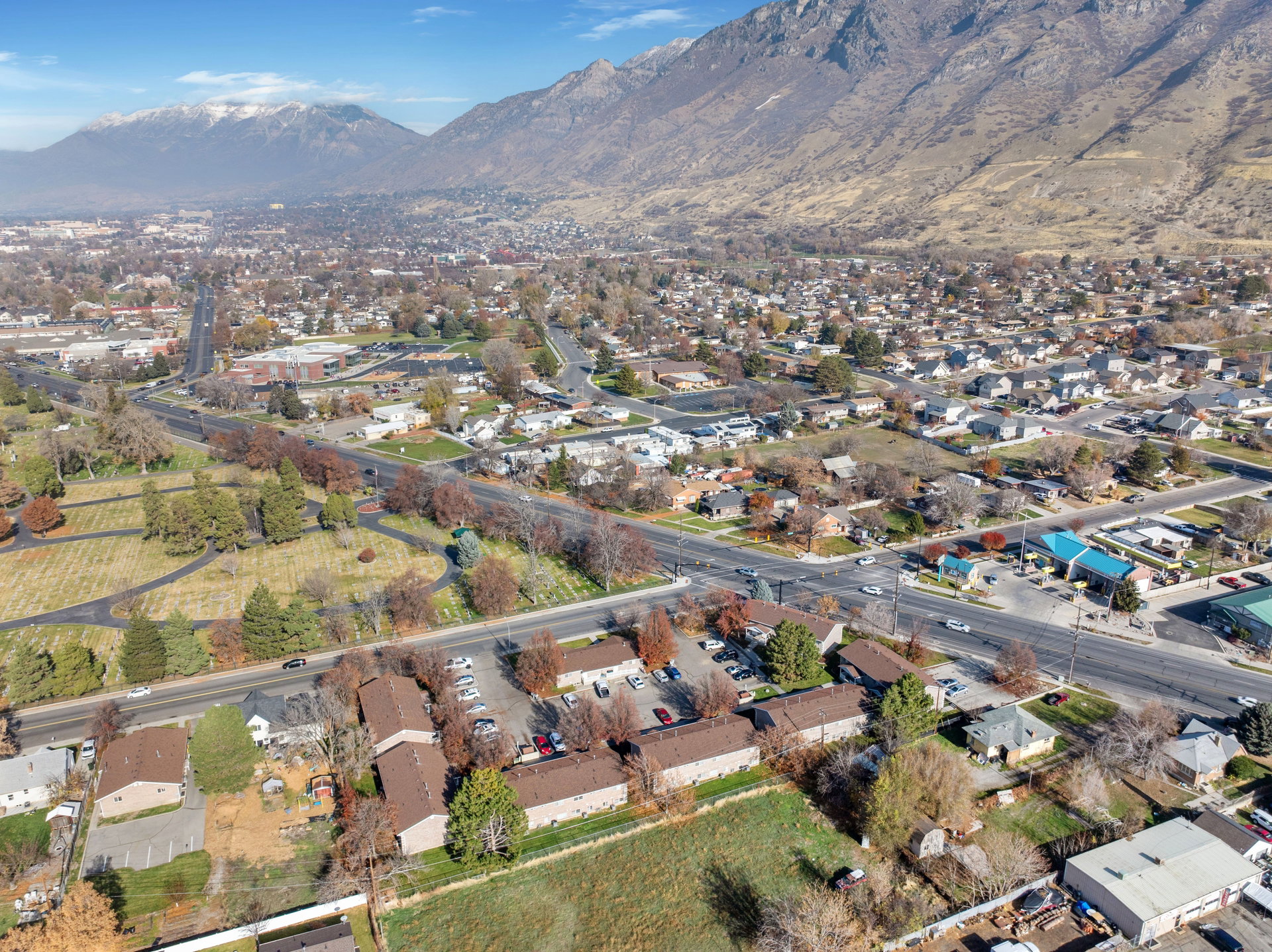 Aerial view of property and surrounding area featuring a mountainous background and nearby suburban area