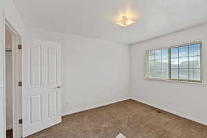 Empty room featuring carpet and baseboards