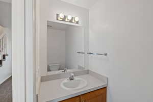 Half bathroom with vanity and toilet