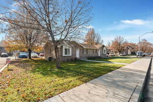 View of front of home featuring a residential view, brick siding, and a front yard