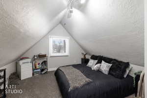 Bedroom featuring carpet, a textured ceiling, and rail lighting