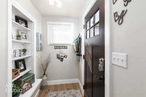 Doorway with wood finished floors and healthy amount of natural light