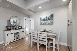 Dining room with light wood-type flooring and recessed lighting