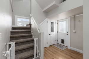 Staircase featuring wood finished floors and a high ceiling