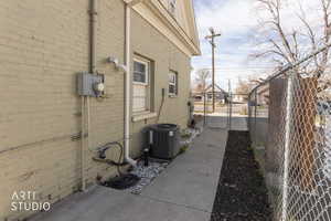 View of side of home with a gate and brick siding