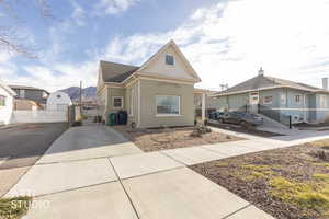 View of front of property featuring a gate, driveway, and brick siding