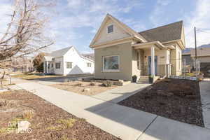 View of front of house with brick siding, a gate, and a shingled roof