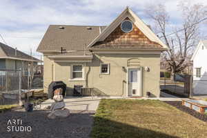 Back of property featuring brick siding, a shingled roof, and a patio