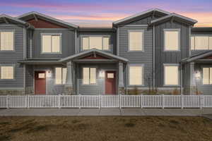 Craftsman inspired home featuring board and batten siding, stone siding, and a fenced front yard