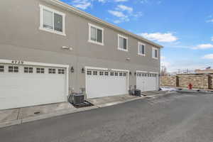 Back of house featuring stucco siding and an attached garage