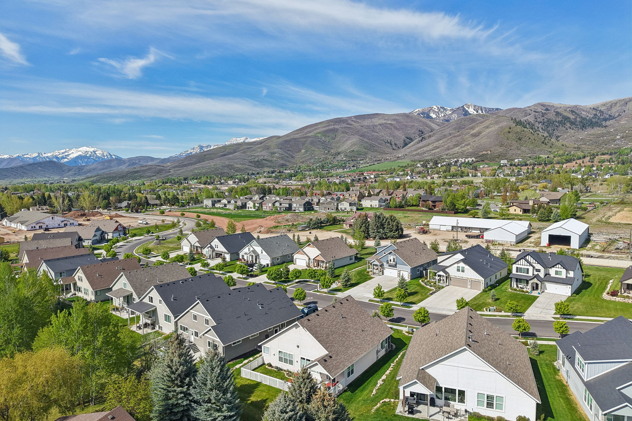 Expansive neighborhood surrounded by green landscaping and distant snow-capped mountains
