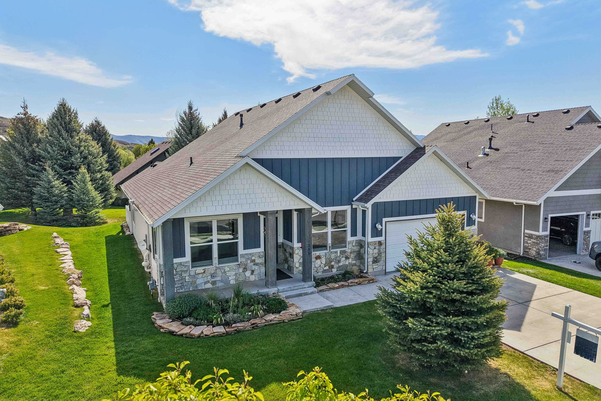 Contemporary residence featuring a combination of horizontal siding, shake siding, and stone veneer accents