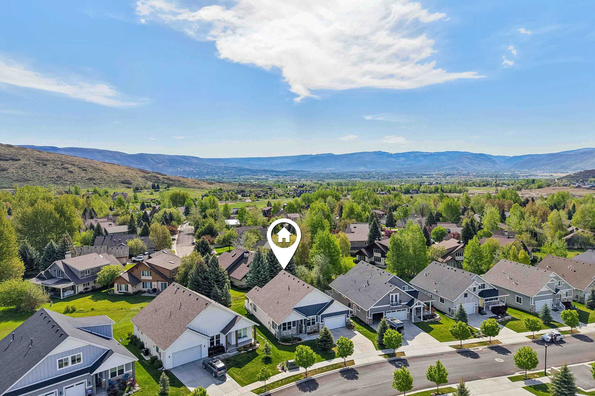 Aerial perspective showcasing a residential street with homes featuring pitched roofs and attached garages