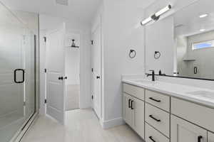 Bathroom with a stall shower and double vanity