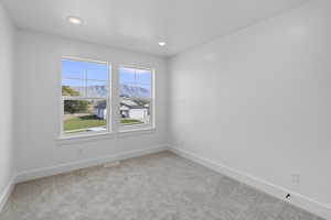 Spare room with a mountain view, light colored carpet, and recessed lighting