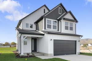 Modern farmhouse with board and batten siding, an attached garage, concrete driveway, and a front lawn
