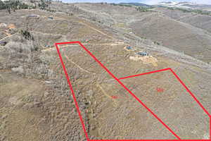 Aerial view of sparsely populated area with property parcel outlined and a mountain backdrop