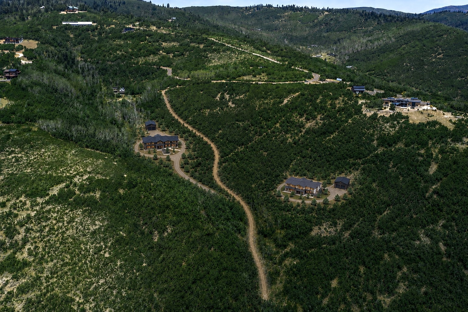 Expansive mountain terrain with winding roads, surrounded by lush green foliage