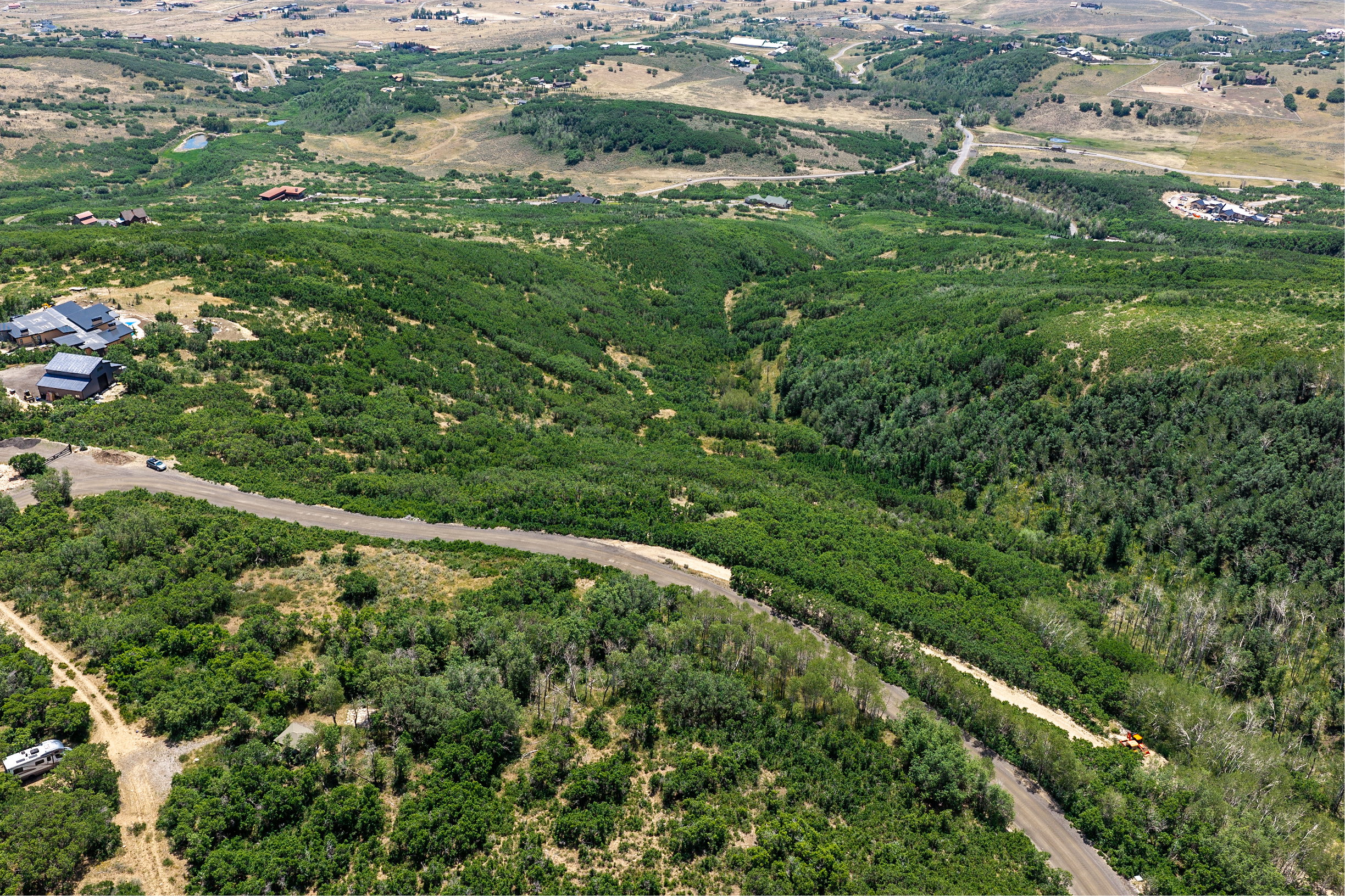 Expansive, verdant landscape with rolling hills and abundant tree coverage