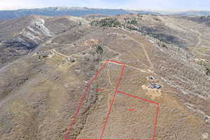 Aerial view of property's location featuring a mountain backdrop and property parcel outlined