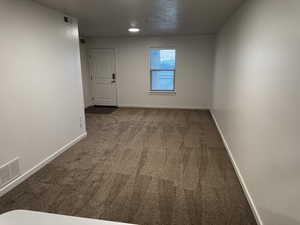 Carpeted spare room featuring baseboards
