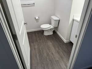 Half bath with vanity and dark wood-style flooring