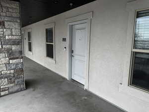 Doorway to property featuring a patio and stucco siding