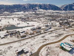 Snowy aerial view with a water and mountain view and a residential view
