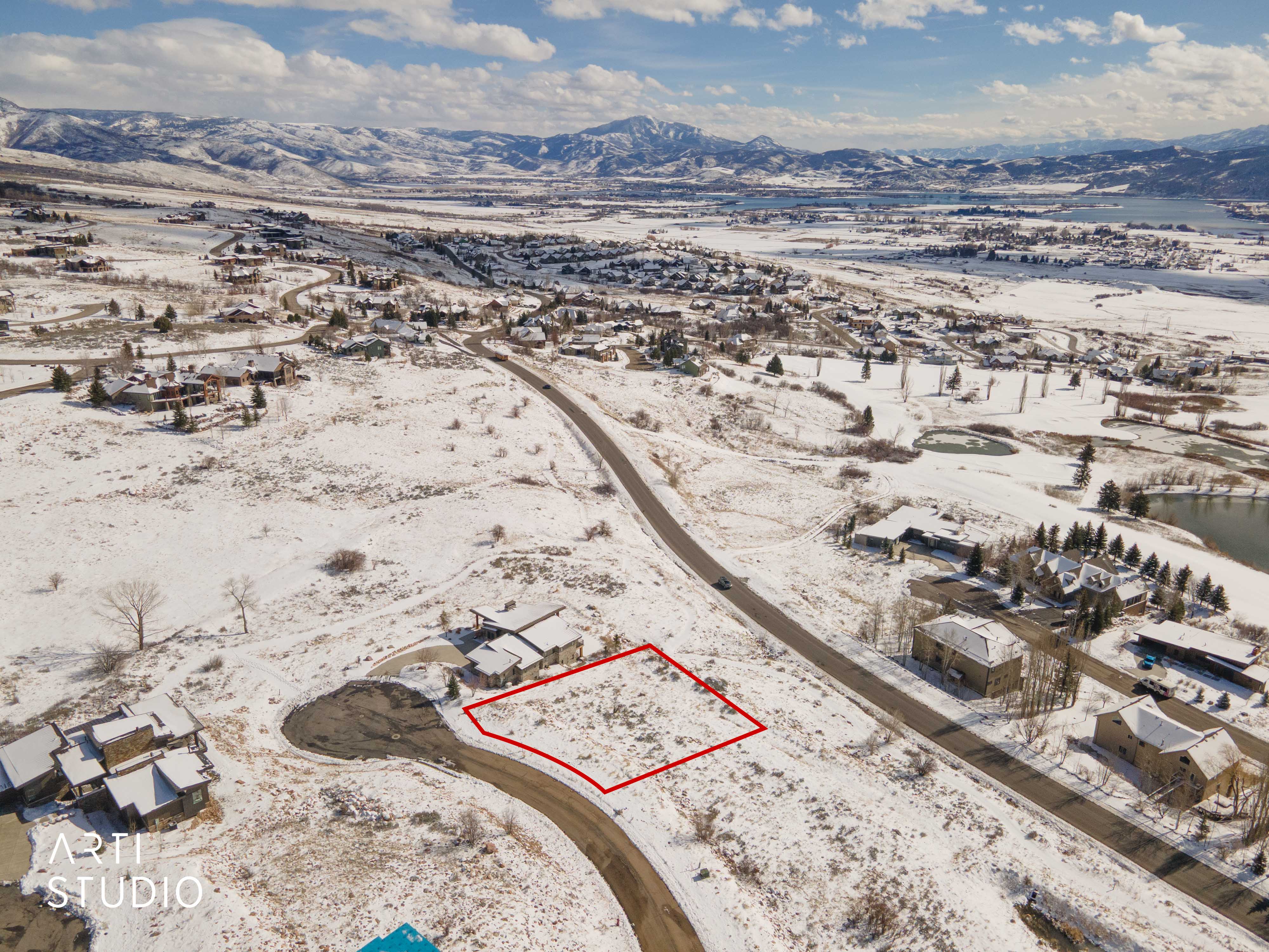 Snowy aerial view with property boundaries highlighted, a mountain view, and a residential view