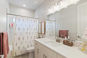 Full bathroom with vanity, shower / bath combination with curtain, and light tile patterned flooring