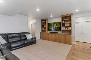 Living area with light wood-type flooring and recessed lighting