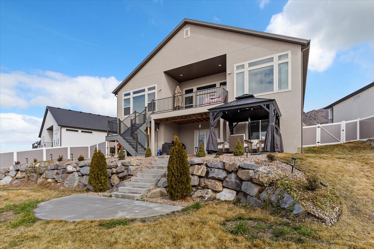 Rear view of property with a patio area, stucco siding, a gate, and a fenced backyard