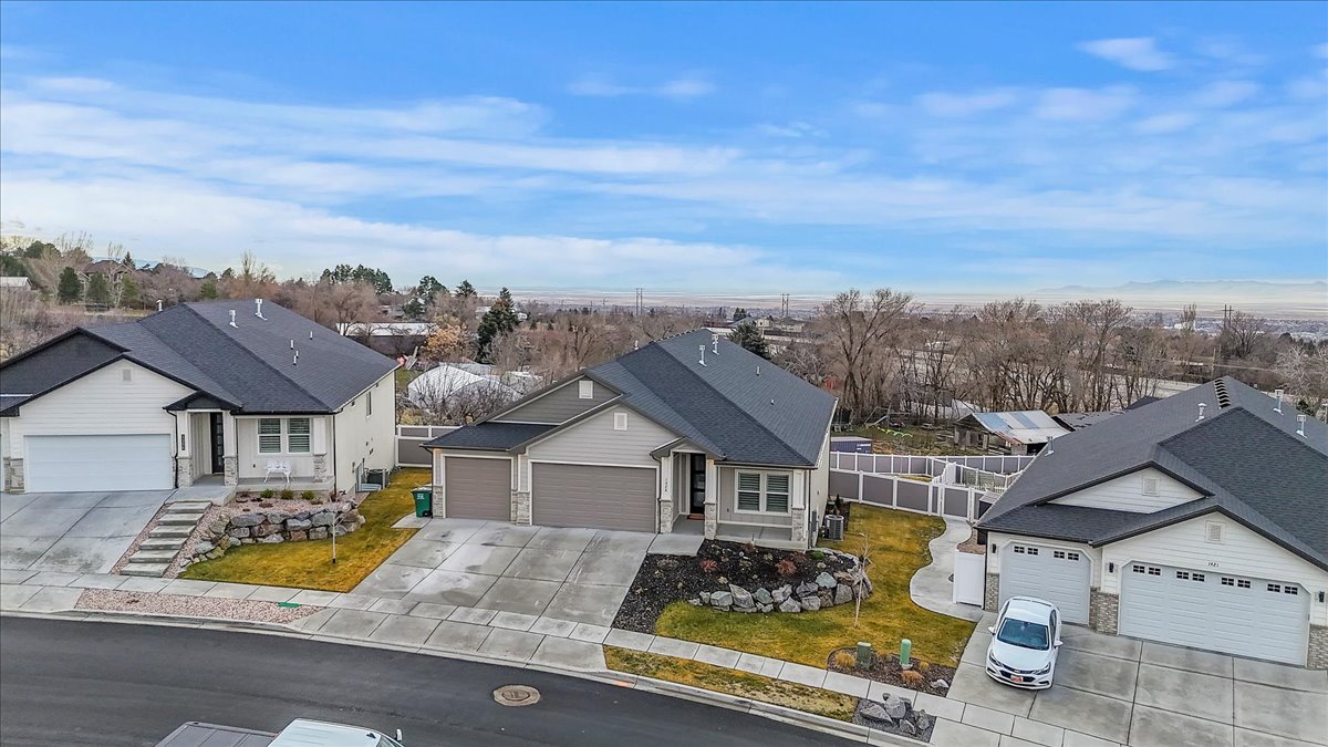 Ranch-style home with an attached garage, driveway, a residential view, and a shingled roof