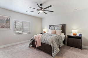 Carpeted bedroom featuring a ceiling fan and baseboards