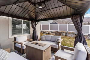 View of patio with an outdoor living space with a fire pit and a gazebo