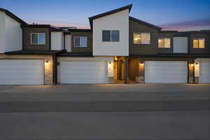 View of front of house featuring stone siding, a garage, and driveway