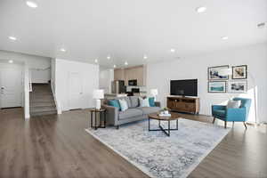 Living room with dark wood-style flooring and recessed lighting