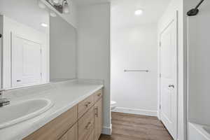 Full bathroom featuring vanity, dark wood-type flooring, and recessed lighting