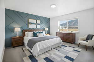 Carpeted bedroom featuring an accent wall and a decorative wall