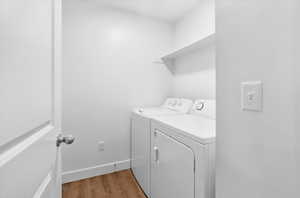 Laundry area with light wood-type flooring and washer and clothes dryer