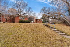 View of front of house with brick siding and a front yard