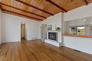 Front room with wood fireplace, vaulted ceilings, hardwood floors and pass thru
