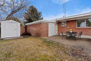 Back of home with patio and shed