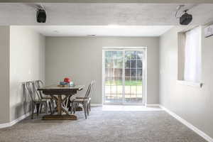 Dining room with light carpet and a textured ceiling