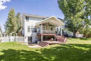 Back of property with a gate, a patio area, a fenced backyard, a ceiling fan, and a deck